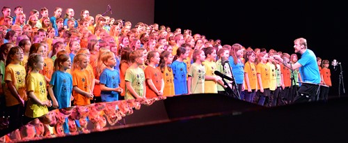 Large choir of children singing at a Songfest concert