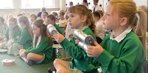 Children playing shaker during a samba workshop